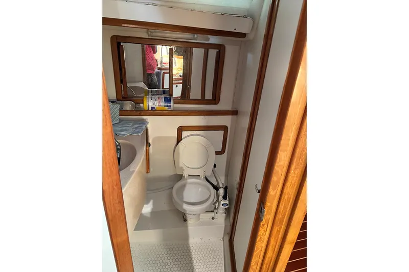 Slide: The Image of 1999 Catalina 42 MkII yacht bathroom with toilet, mirror, and wooden accents. - 18