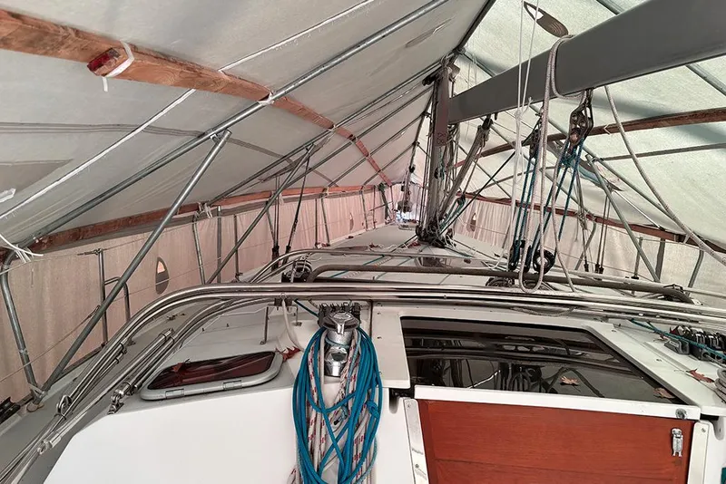 Slide: The Image of 1999 Catalina 42 MkII sailboat under protective cover with visible rigging and deck. - 6