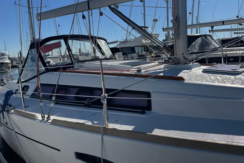 Slide: The Image of 2014 Beneteau Oceanis 34 sailboat docked in a marina under clear blue skies. - 10