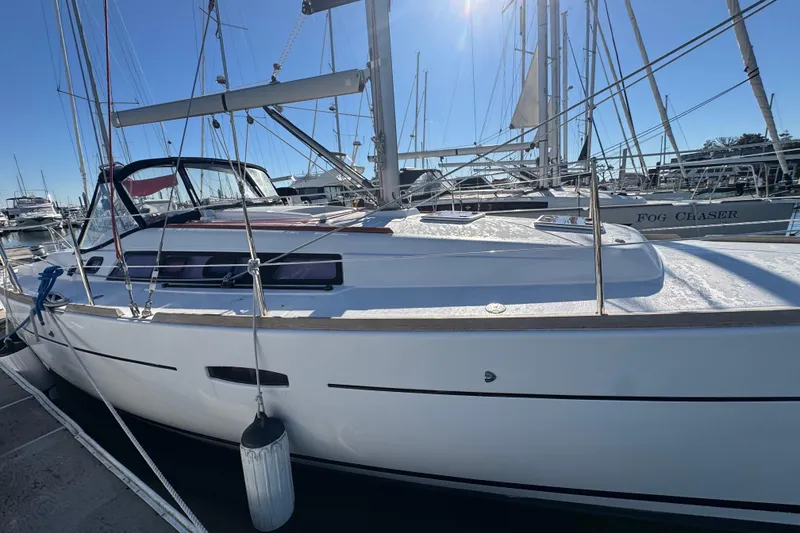 Slide: The Image of 2014 Beneteau Oceanis 34 sailboat docked in a sunny marina. - 11