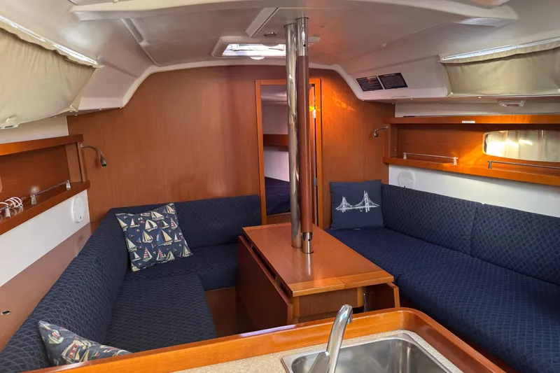 Slide: The Image of Interior of 2014 Beneteau Oceanis 34 sailboat with cozy seating and wooden finishes. - 17