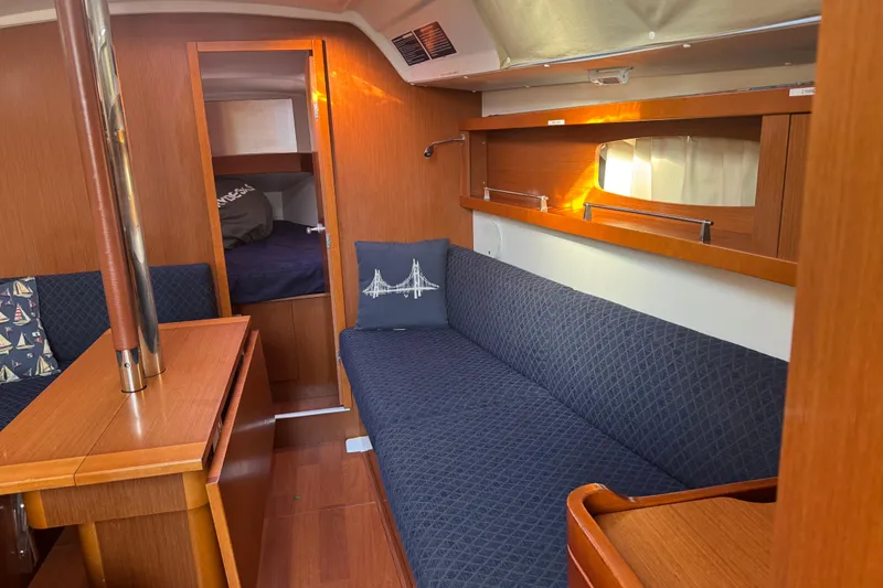 Slide: The Image of Interior of 2014 Beneteau Oceanis 34 sailboat with cozy seating and wooden finishes. - 21