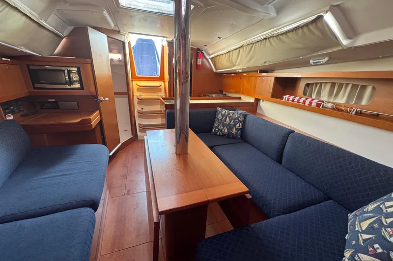 Slide: The Image of Interior of 2014 Beneteau Oceanis 34 sailboat with cozy seating and wooden finishes. - 23