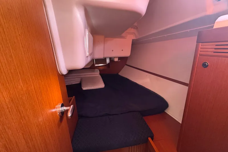 Slide: The Image of 2014 Beneteau Oceanis 34 cabin interior with wooden finish and cozy sleeping area. - 33