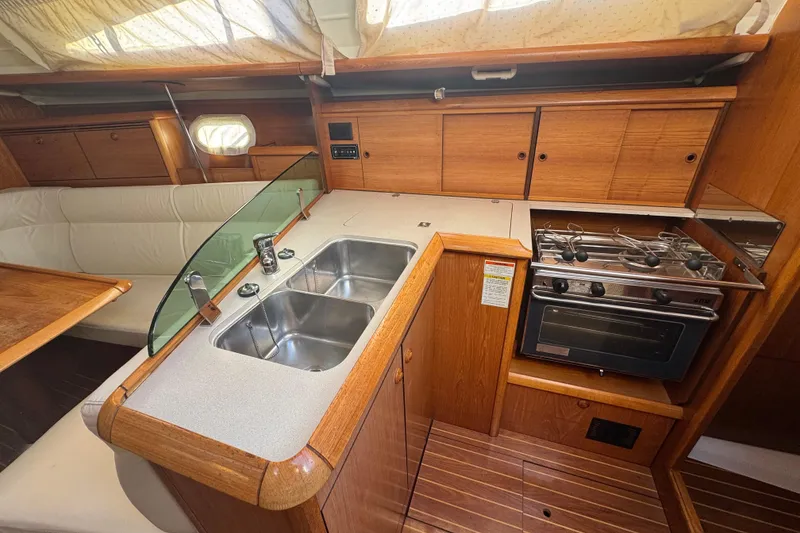 Slide: The Image of 2004 Jeanneau Sun Fast 35 yacht interior with kitchen, dual sinks, and stove. - 14