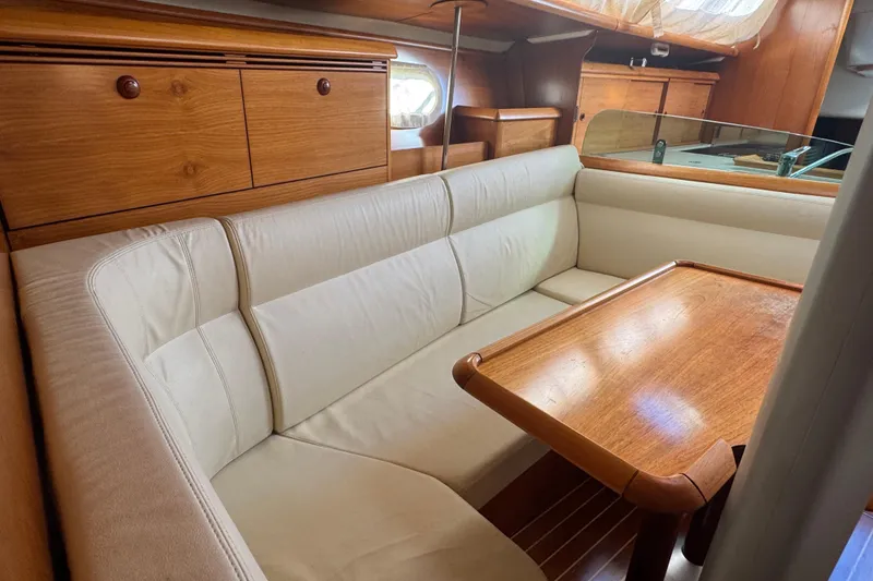 Slide: The Image of Luxurious interior of 2004 Jeanneau Sun Fast 35 sailboat with wooden table and beige seating. - 16