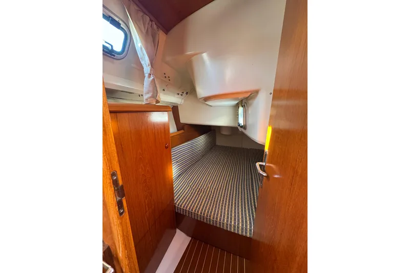 Slide: The Image of 2004 Jeanneau Sun Fast 35 cabin interior with wood finish and striped bedding. - 20
