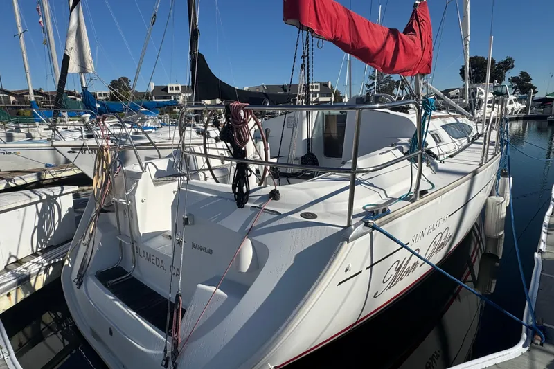 Slide: The Image of 2004 Jeanneau Sun Fast 35 sailboat docked in marina, featuring red sail cover. - 7