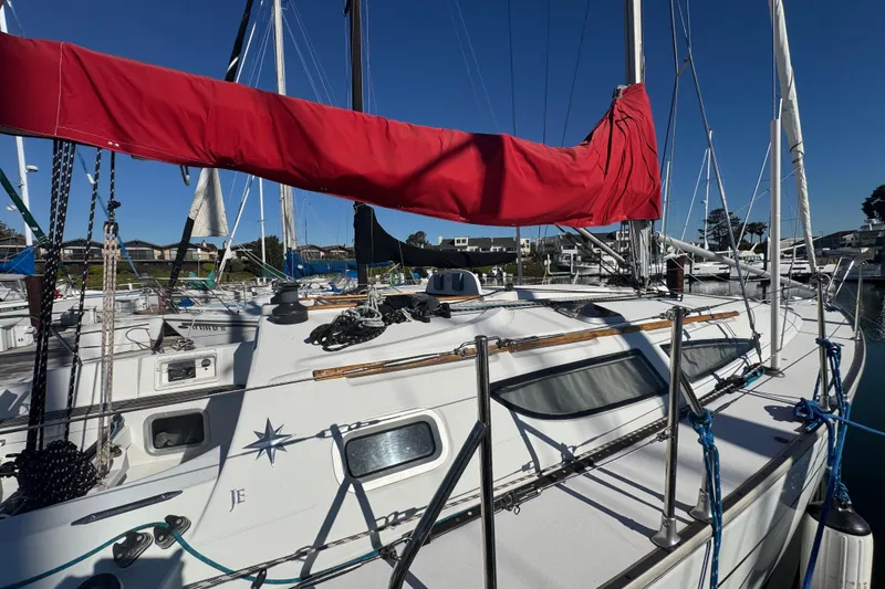 Slide: The Image of 2004 Jeanneau Sun Fast 35 sailboat with red sail cover docked in marina. - 8