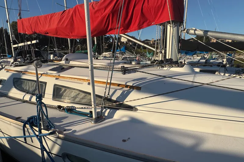 Slide: The Image of 2004 Jeanneau Sun Fast 35 sailboat with red sail cover, docked in marina. - 9