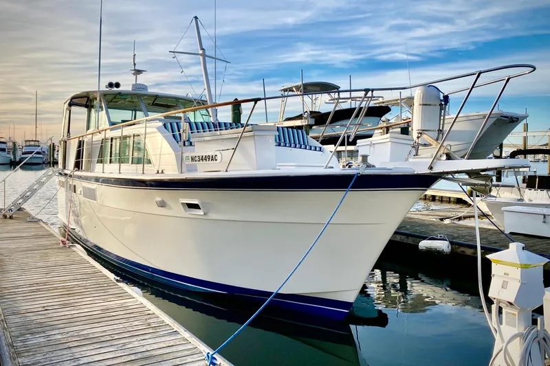 The Image of 1971 Hatteras 43 Double Cabin yacht docked at marina, clear sky background. - 0