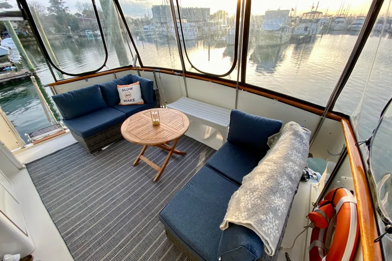 Slide: The Image of 1971 Hatteras 43 Double Cabin interior with wooden door, decorative items, and marina view. - 34