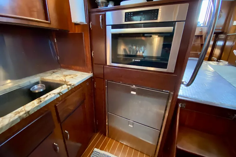 Slide: The Image of 1971 Hatteras 43 Double Cabin kitchen with stove, knives, and kettle on marble countertop. - 55