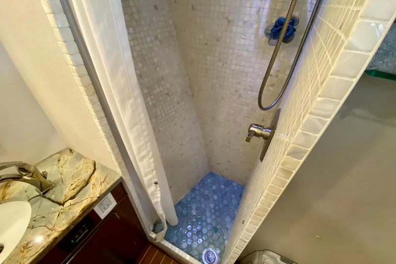 Slide: The Image of Bathroom shelves on 1971 Hatteras 43 Double Cabin with towels and toiletries. - 62