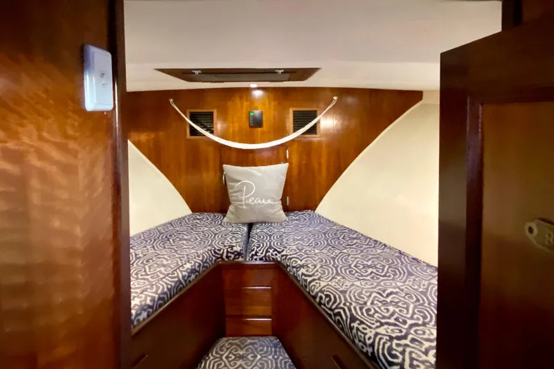 Slide: The Image of 1971 Hatteras 43 Double Cabin interior with patterned bedding and small window. - 65