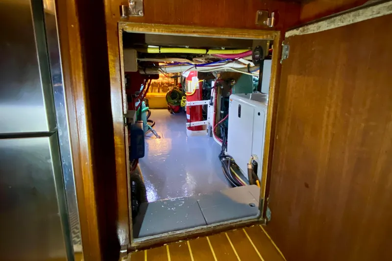 Slide: The Image of Engine room of a 1971 Hatteras 43 Double Cabin with fire extinguisher and wiring. - 96