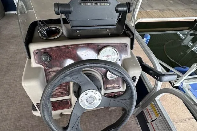 Slide: The Image of 2024 Sun Tracker Bass Buggy 18 DLX steering console with gauges and controls. - 12