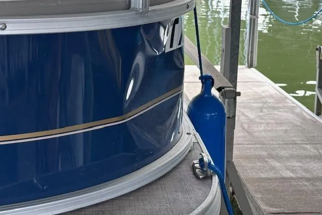 Slide: The Image of 2024 Sun Tracker Bass Buggy 18 DLX pontoon boat docked with blue fender. - 15
