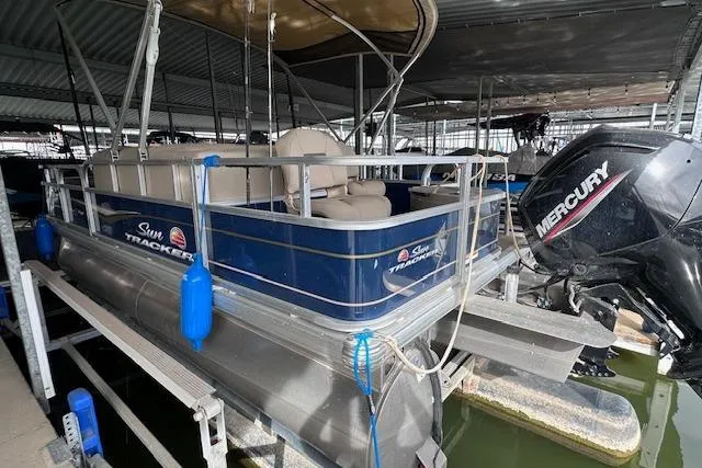 Slide: The Image of 2024 Sun Tracker Bass Buggy 18 DLX pontoon boat with Mercury engine in marina. - 3