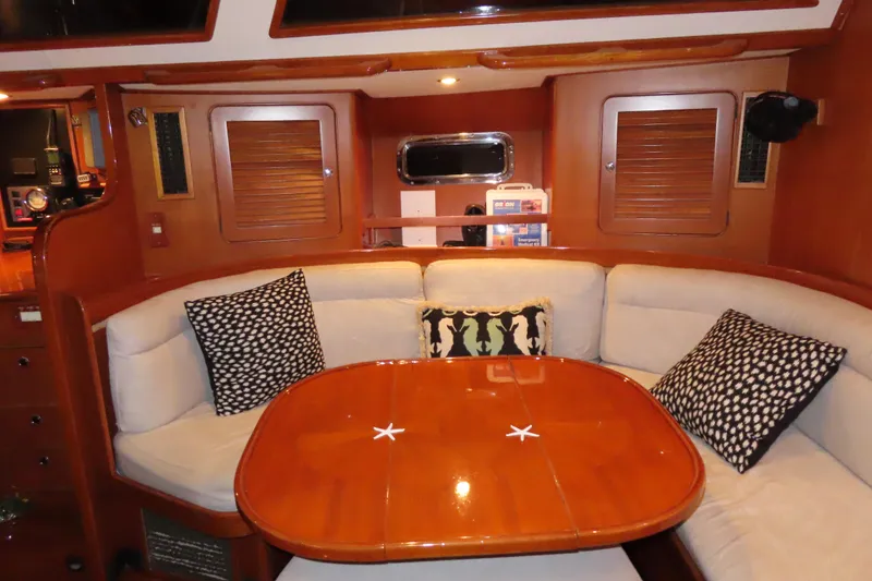 Slide: The Image of Luxurious 1998 Hylas 54' yacht interior with cozy seating and elegant wooden table. - 17