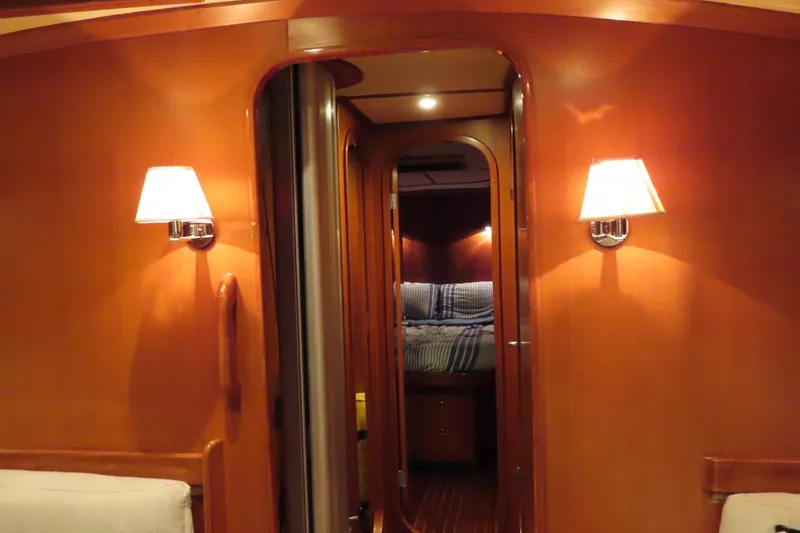 Slide: The Image of Interior of 1998 Hylas 54' yacht with warm wood paneling and cozy lighting. - 18