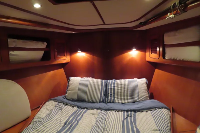 Slide: The Image of Cozy cabin interior of 1998 Hylas 54' yacht with striped bedding and warm lighting. - 21