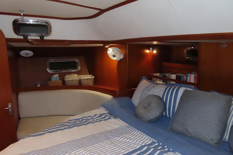 Slide: The Image of Cozy cabin interior of 1998 Hylas 54' yacht with striped bedding and wooden accents. - 26