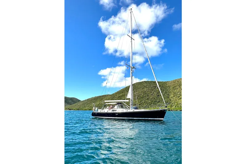 Slide: The Image of Sailing yacht Hylas 54' (1998) on blue water with green hills and clear sky. - 4