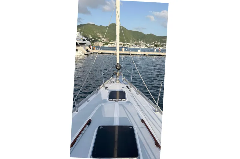 Slide: The Image of Sailing yacht Hylas 54' (1998) docked at a scenic marina with hills in the background. - 7
