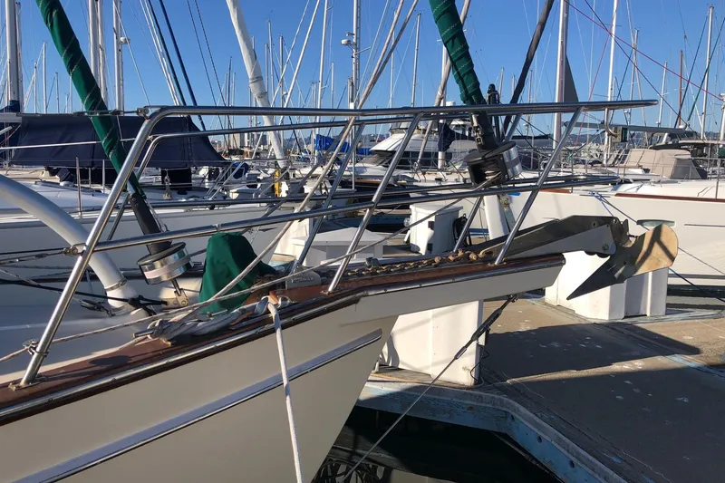 Slide: The Image of 1997 Island Packet 350 sailboat docked at a marina, featuring a sturdy bow and anchor. - 18