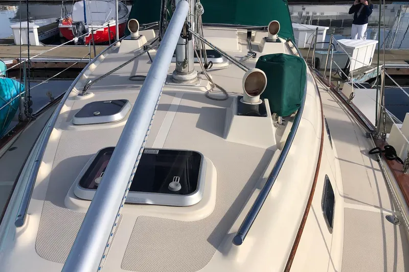 Slide: The Image of 1997 Island Packet 350 sailboat deck with hatches and rigging, docked at marina. - 20