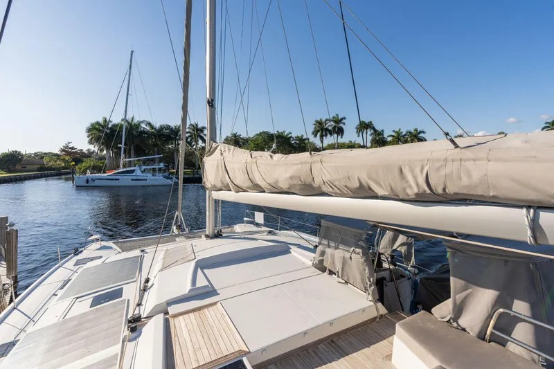 Slide: The Image of 2019 Fountaine Pajot 47 catamaran docked on a sunny day with palm trees in the background. - 11