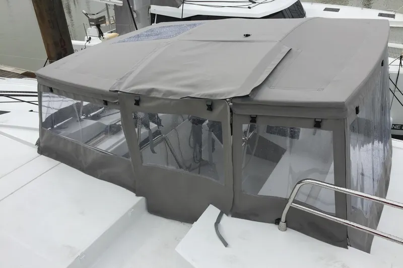 Slide: The Image of 2019 Saona 47 yacht with gray cockpit enclosure, docked at marina. - 12