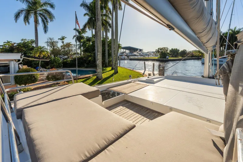 Slide: The Image of Luxurious 2019 Fountaine Pajot 47 catamaran with sunbathing area, docked by palm trees. - 16