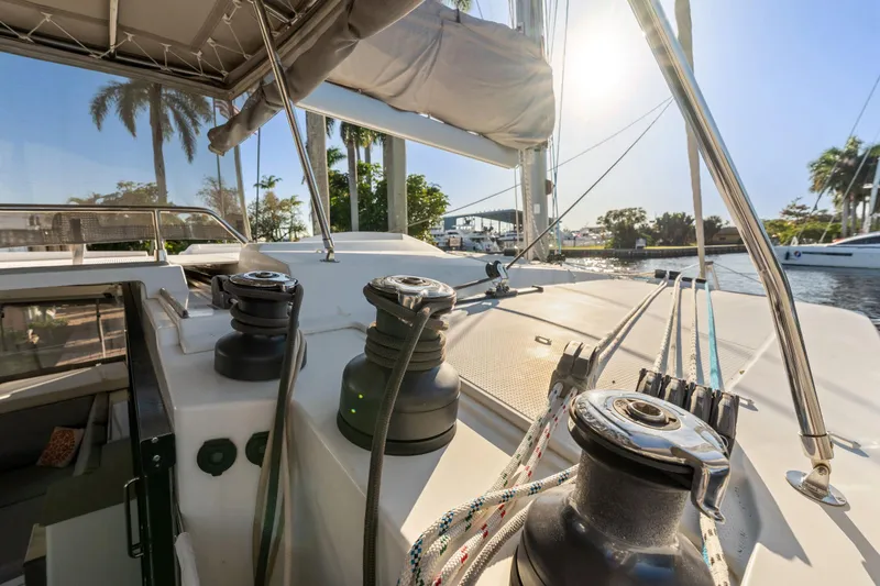 Slide: The Image of 2019 Fountaine Pajot 47 catamaran deck with winches and ropes, sunny marina view. - 17