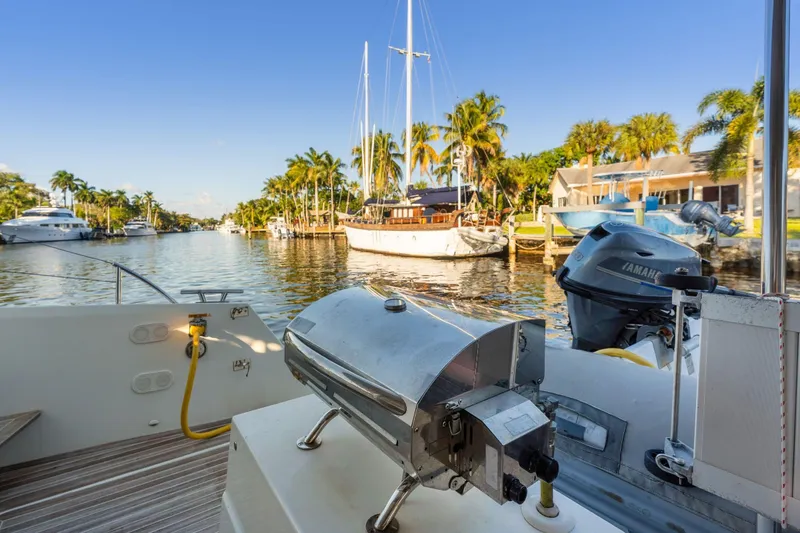 Slide: The Image of 2019 Fountaine Pajot 47 yacht with grill, docked in a scenic canal with palm trees. - 36