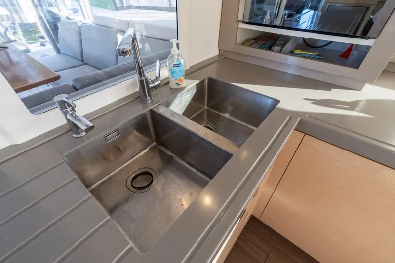 Slide: The Image of Modern kitchen sink area on 2019 Fountaine Pajot 47 yacht, featuring dual stainless steel basins. - 45