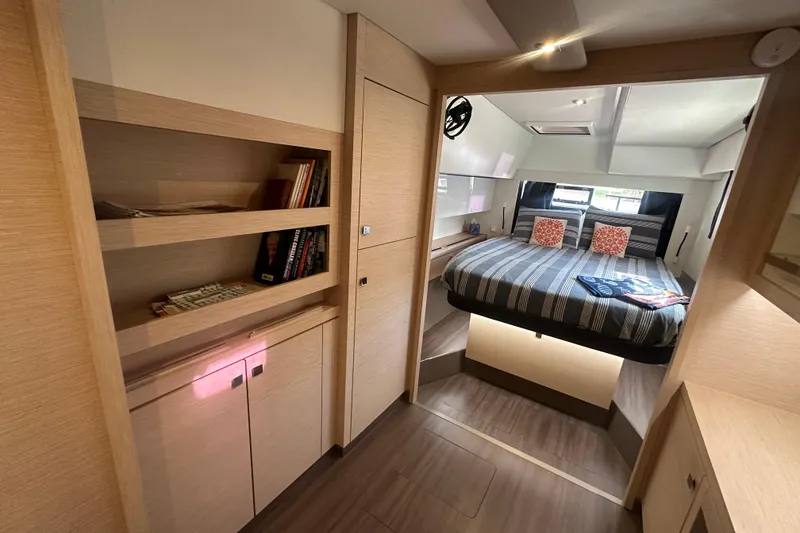 Slide: The Image of Luxurious 2019 Fountaine Pajot 47 yacht interior with cozy bedroom and modern wooden shelving. - 46