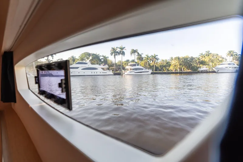 Slide: The Image of View from 2019 Fountaine Pajot 47 yacht window, overlooking serene waterfront with palm trees. - 57