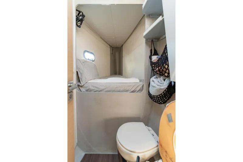 Slide: The Image of 2019 Fountaine Pajot 47 interior cabin with bed, shelves, and compact toilet. - 60