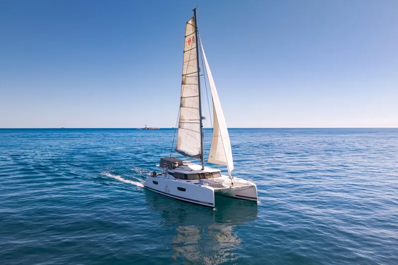 Slide: The Image of 2019 Fountaine Pajot 47 catamaran sailing on open blue sea under clear sky. - 78