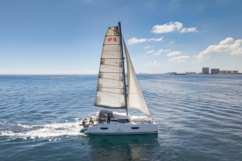 Slide: The Image of 2019 Fountaine Pajot 47 catamaran sailing on calm ocean waters under a clear blue sky. - 79
