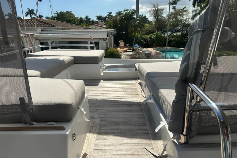 Slide: The Image of 2019 Fountaine Pajot 47 yacht deck with cushioned seating and scenic view. - 8
