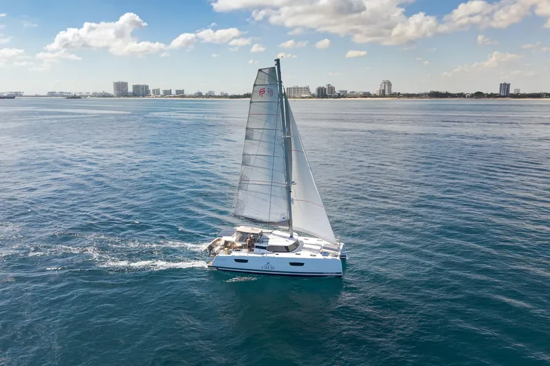 Slide: The Image of 2019 Fountaine Pajot 47 sailing on calm ocean near city skyline. - 80