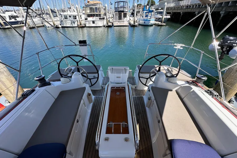 Slide: The Image of 2015 Jeanneau Sun Odyssey 409 sailboat cockpit with dual steering wheels in marina. - 25
