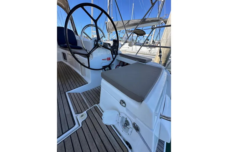 Slide: The Image of 2015 Jeanneau Sun Odyssey 409 cockpit with steering wheel and seating, docked at marina. - 29