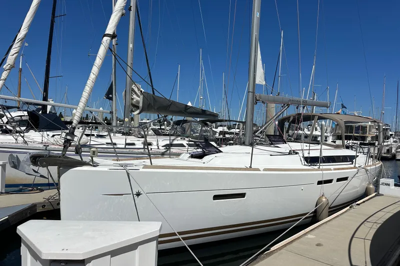 Slide: The Image of 2015 Jeanneau Sun Odyssey 409 sailboat docked at marina under clear blue sky. - 3