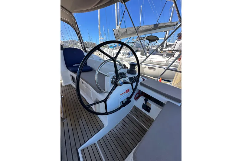 Slide: The Image of Steering wheel of 2015 Jeanneau Sun Odyssey 409 sailboat, docked with visible deck and seating. - 32