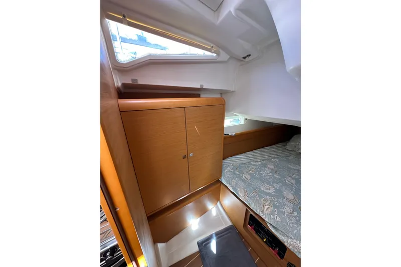 Slide: The Image of Interior cabin of 2015 Jeanneau Sun Odyssey 409 sailboat with wooden cabinetry and bed. - 49