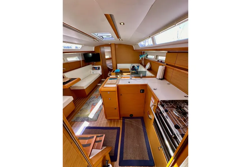 Slide: The Image of Interior of 2015 Jeanneau Sun Odyssey 409 yacht, featuring modern kitchen and cozy seating area. - 50